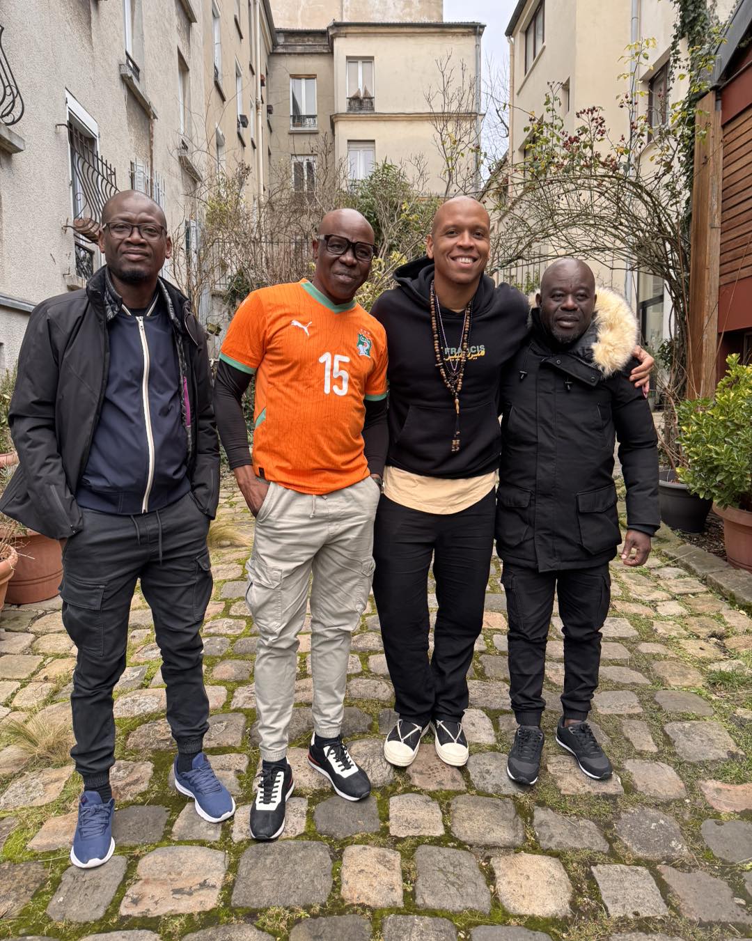 Francis Mercier and Magic System members, including lead singer A'salfo in an orange Ivory Coast jersey, posing together.