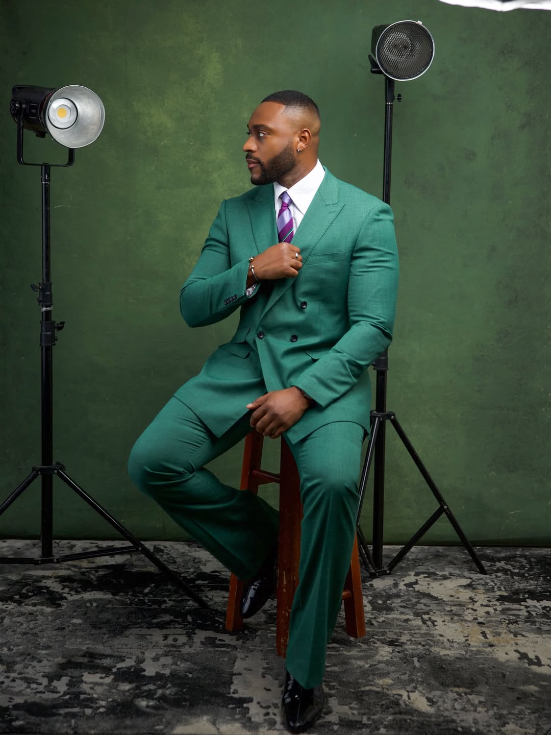 Kola Omotosho in a sharp teal double-breasted suit and a purple striped silk tie at the "Mother's Love" film premiere by Omotola Jalade-Ekeinde in Lagos, Nigeria.