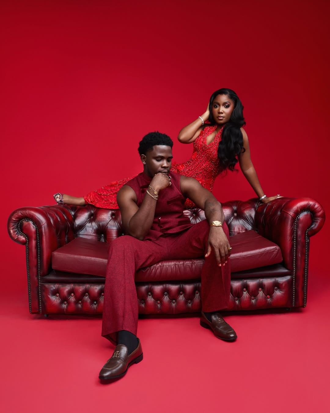 Lifestyle influencer Simi Sanya in a crystal-beaded red gown and film producer Femi Dapson in a deep burgundy suit for their pre-wedding photo shoot.