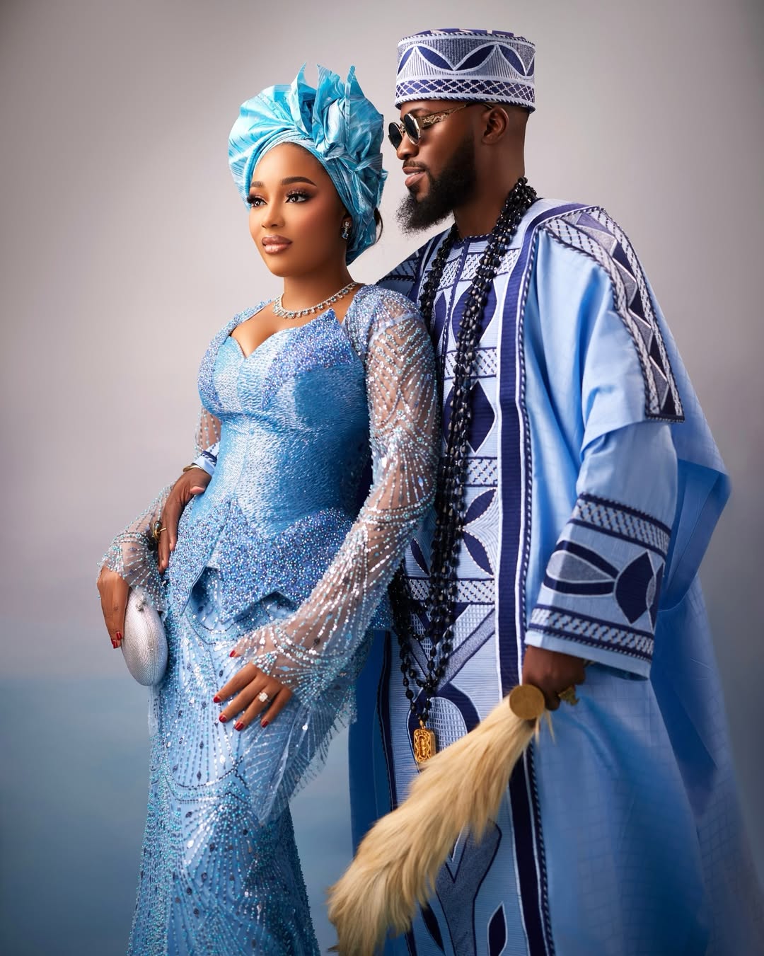 Akin Faminu and Kiky Festus posing together in coordinated powder blue traditional outfits for Simi Sanya and Femi Dapson's traditional wedding ceremony.