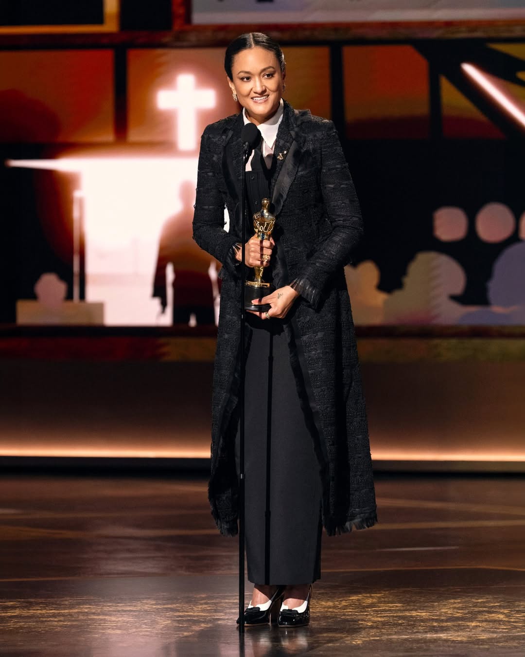 Cinematographer Autumn Durald Arkapaw speaking at the podium while holding her Oscar for Best Cinematography for the film Sinners at the 98th Academy Awards.