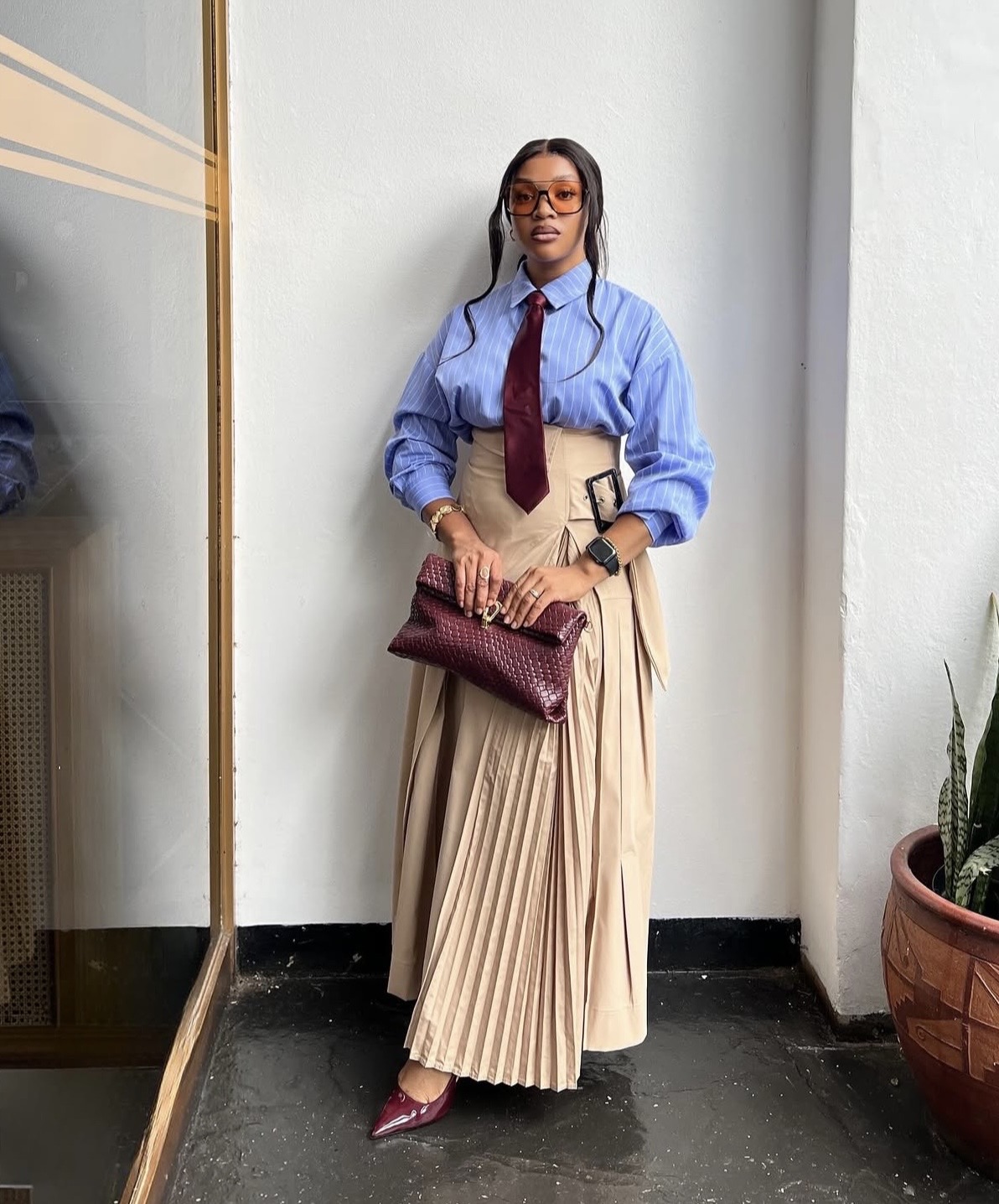 Striped button-down shirt paired with pleated asymmetrical maxi skirt and necktie— A-line maxi skirt styling tips