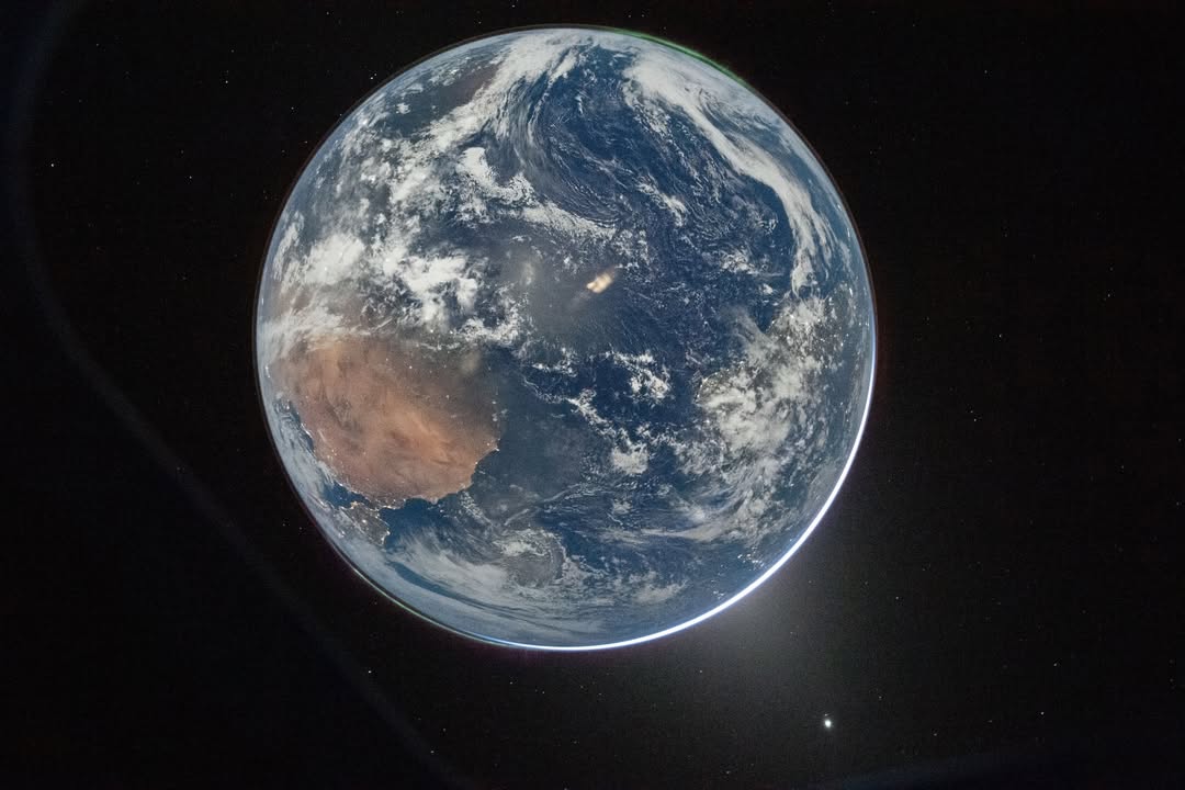 High-resolution full disk image of Earth from space showing the African continent, aurora, and city lights from the Orion capsule.