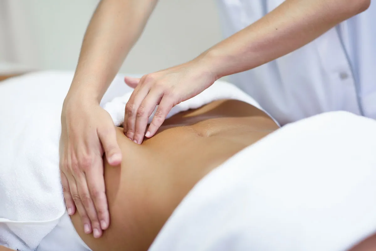 woman receiving a belly massage ― Lymphatic drainage supplements benefits