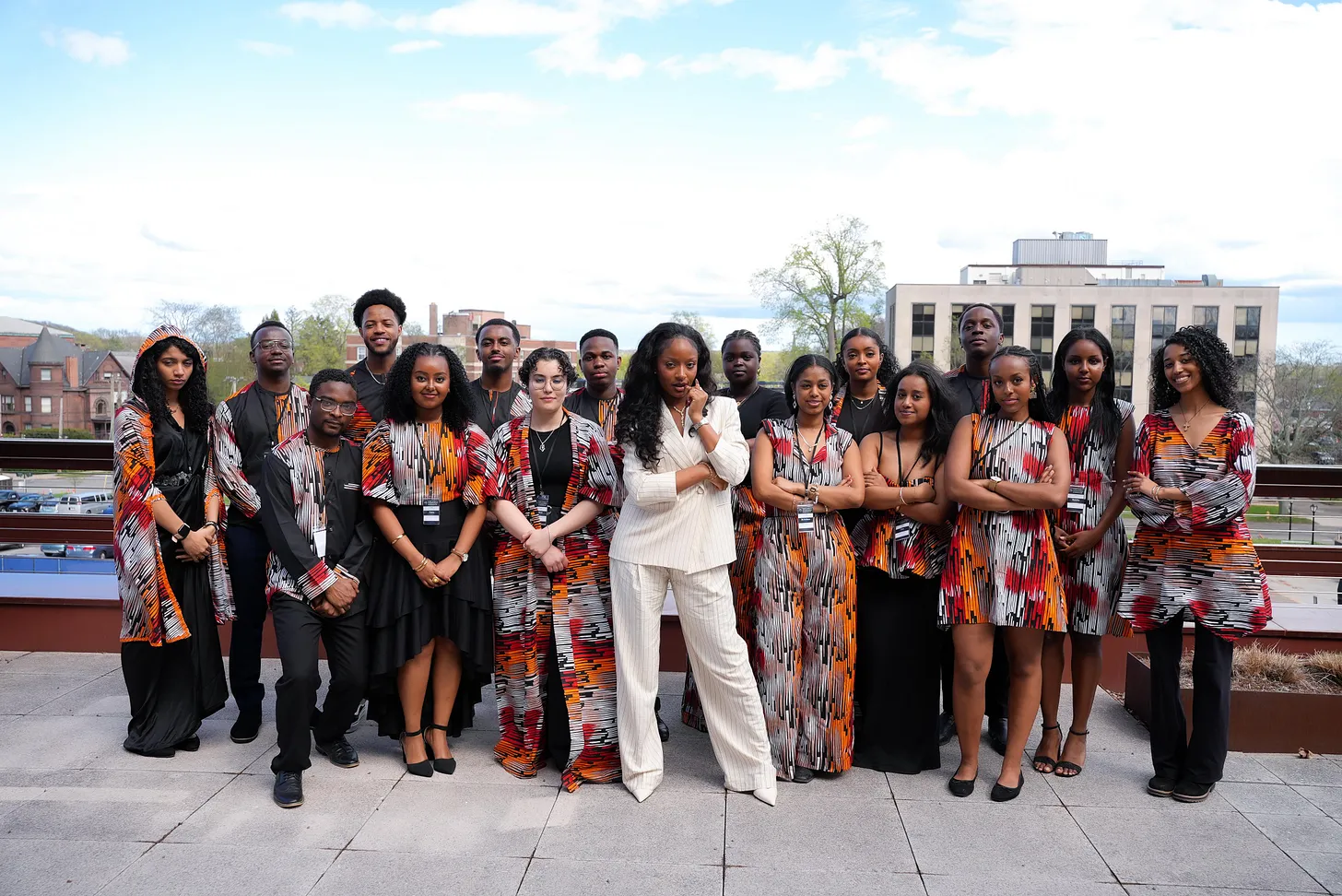 Ayra Starr posing with a diverse group of students from the Yale Africa Innovation Society on an outdoor terrace.