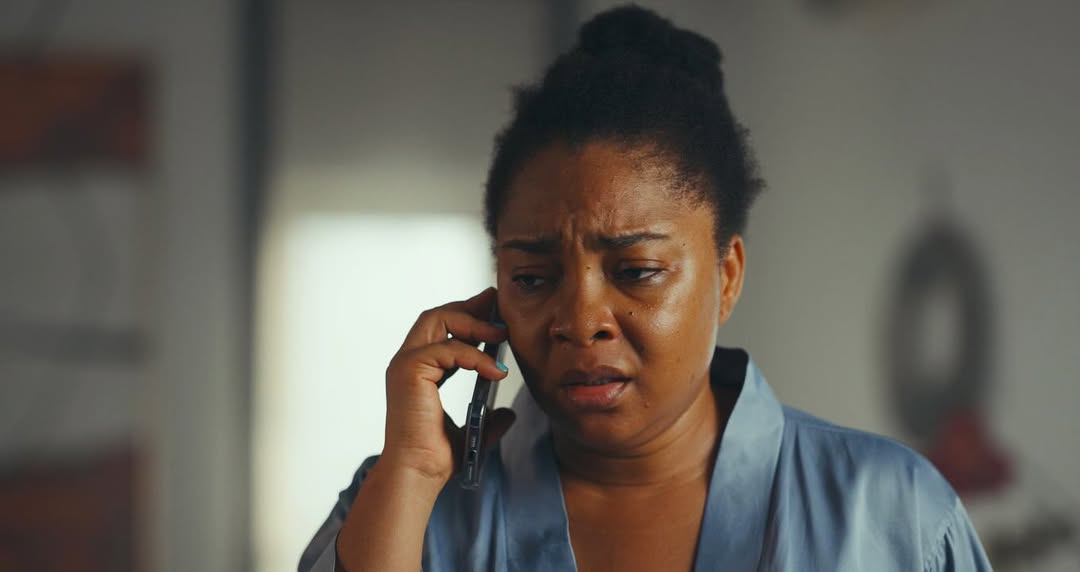 Linda Ejiofor-Suleiman as Adamma in The Herd, showing a distressed expression during a phone call.