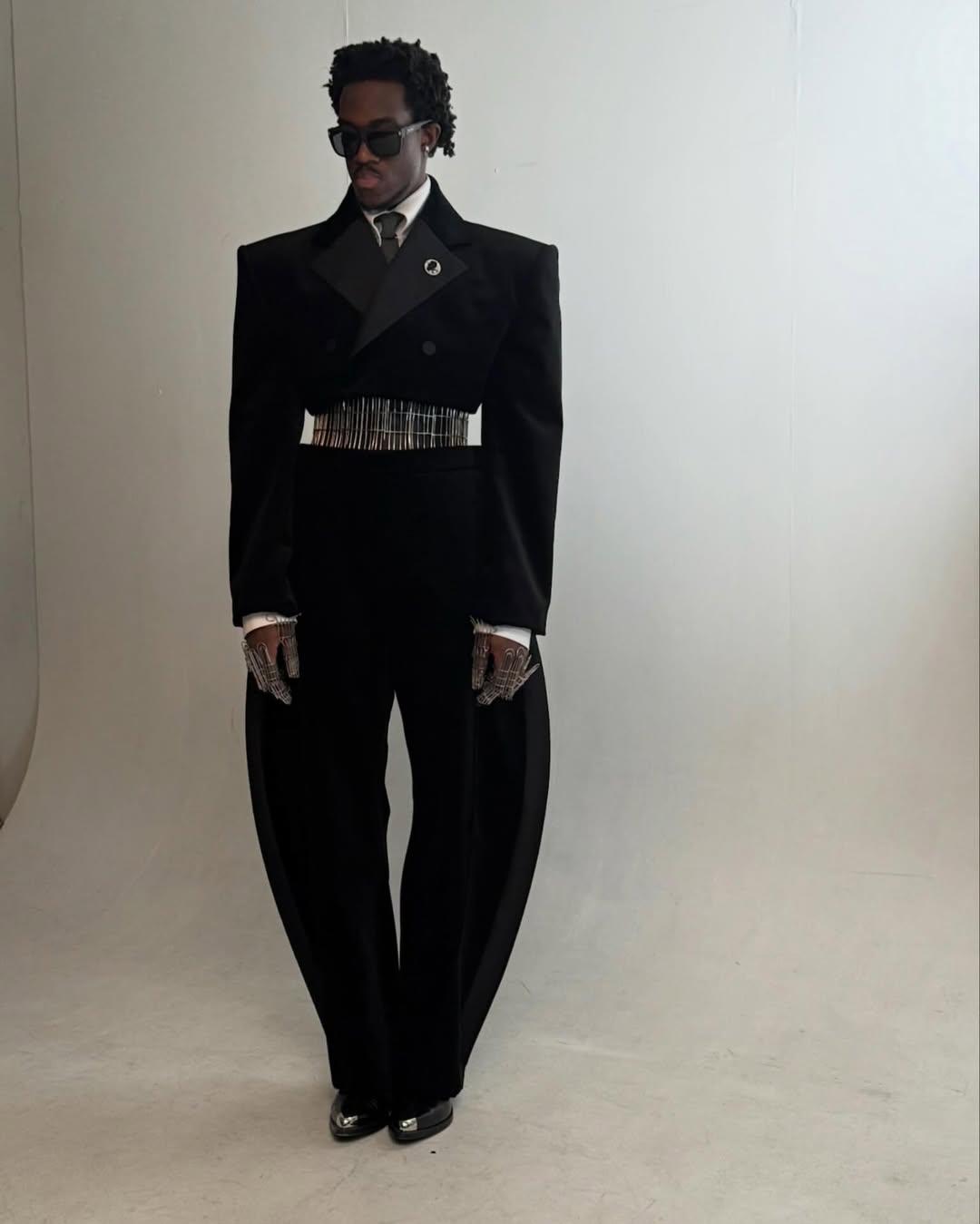 Fashion creator Wisdom Kaye in a studio setting wearing a custom velvet and silk faille Public School New York suit and a leather corset belt for the 2026 Met Gala.