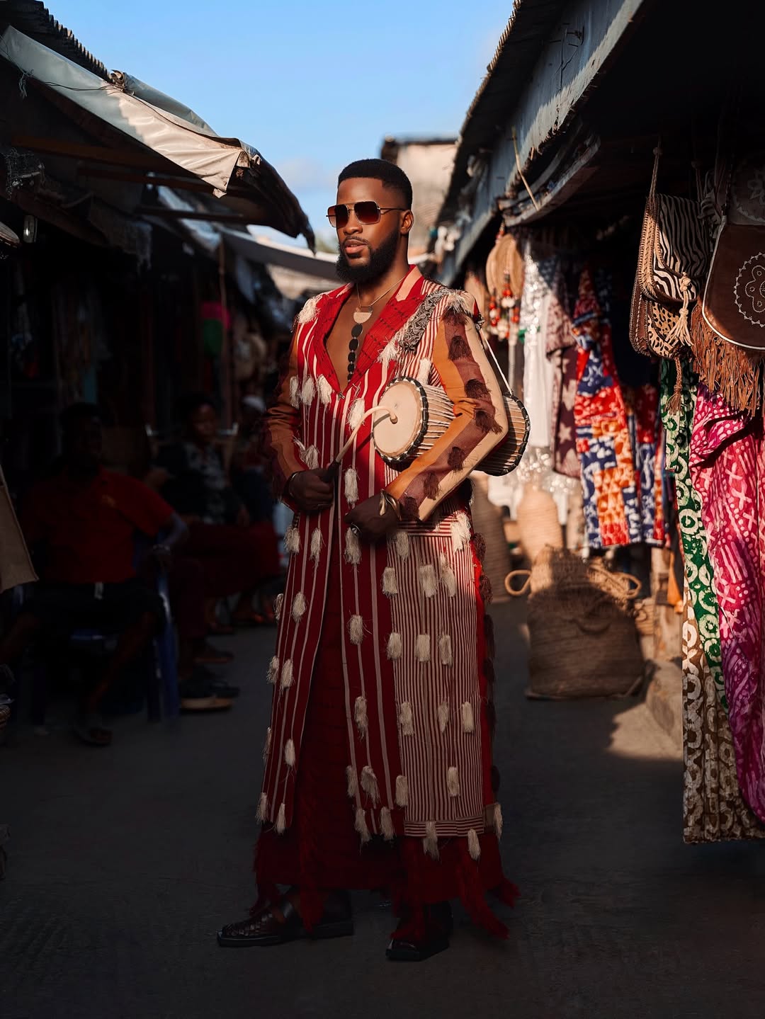 Akin Faminu wearing a traditional red Aso-Oke robe by Y'Wande as a 2026 Met Gala "Costume Art" interpretation, photographed by Oj Mayana.