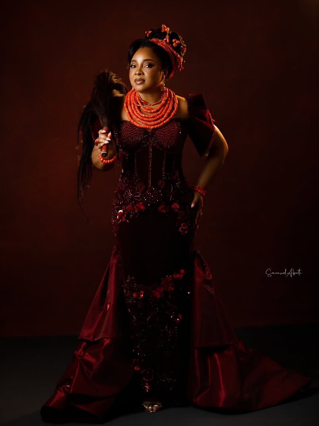 Linda Ejiofor-Suleiman in a wine velvet corset dress and traditional Edo Okuku coral bead crown for AMVCA 12.