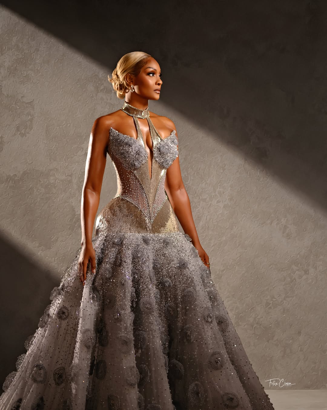 Osas Ighodaro posing in a silver embellished corset gown by Veekee James for AMVCA 12.
