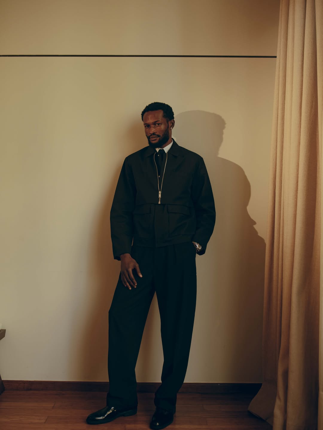 Bucci Franklin in a structured black utility-style jacket and matching trousers for the 12th AMVCA ceremony in Lagos.