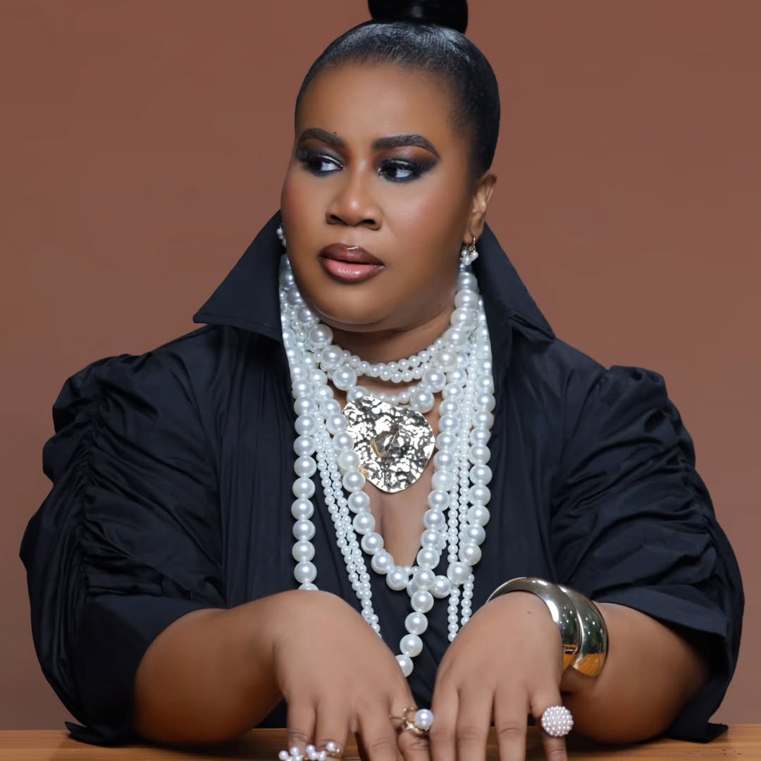 Close-up of Chioma "Chigurl" Omeruah’s birthday glam featuring smoky eyes, a sleek top knot, and layered pearl necklaces.