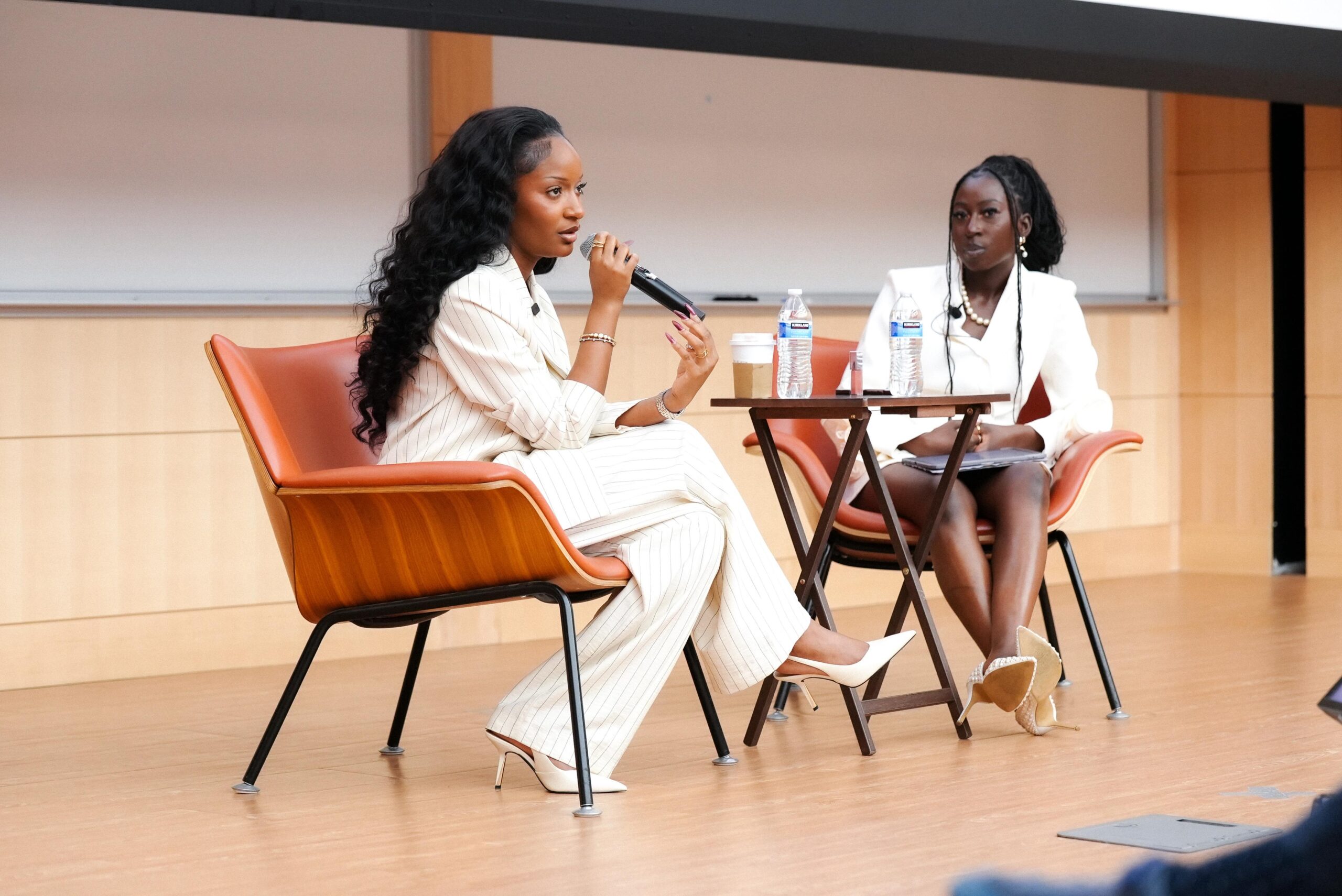 Ayra Starr speaking into a microphone during a panel discussion at the Yale Africa Innovation Symposium.
