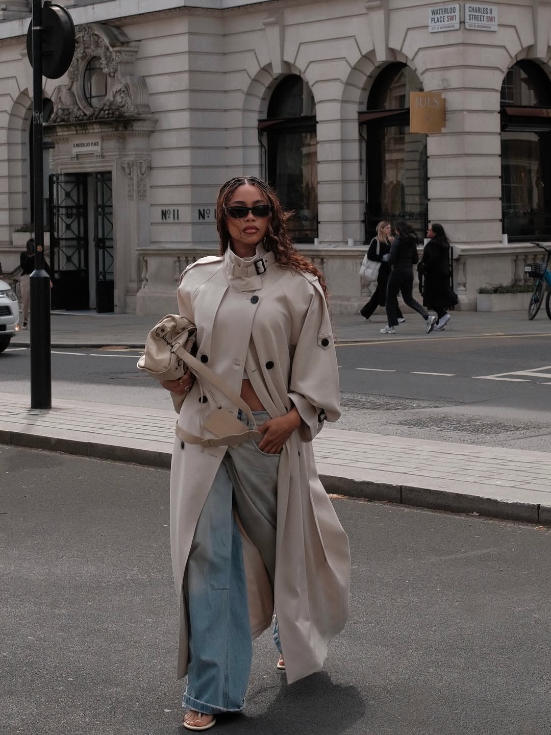 woman wearing lightweight trench jacket in spring with white tee and jeans outfit