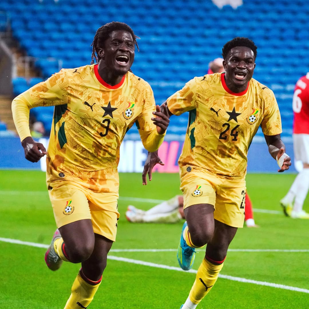 Caleb Yirenkyi shouting in celebration alongside teammate number 24 after scoring his first senior international goal for Ghana against Wales.