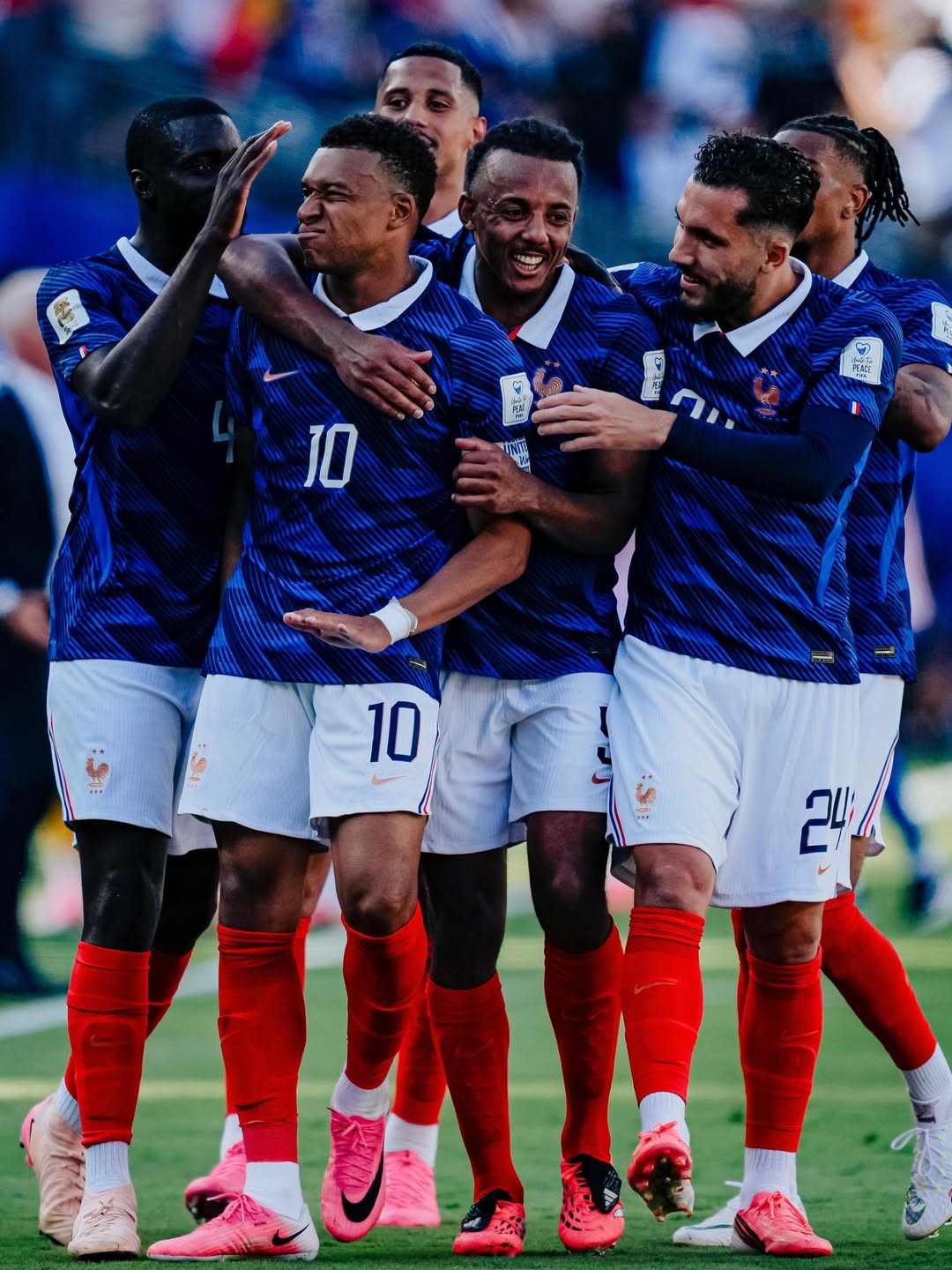 Kylian Mbappe surrounded and embraced by his French teammates after netting a goal against Senegal.