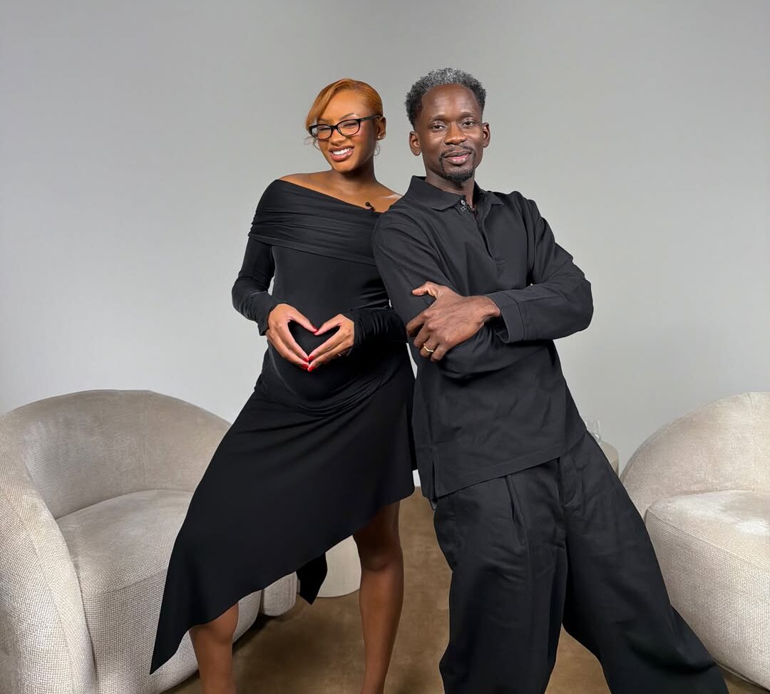 Temi Otedola shapes her hands into a heart over her baby bump alongside Mr Eazi on a studio set.