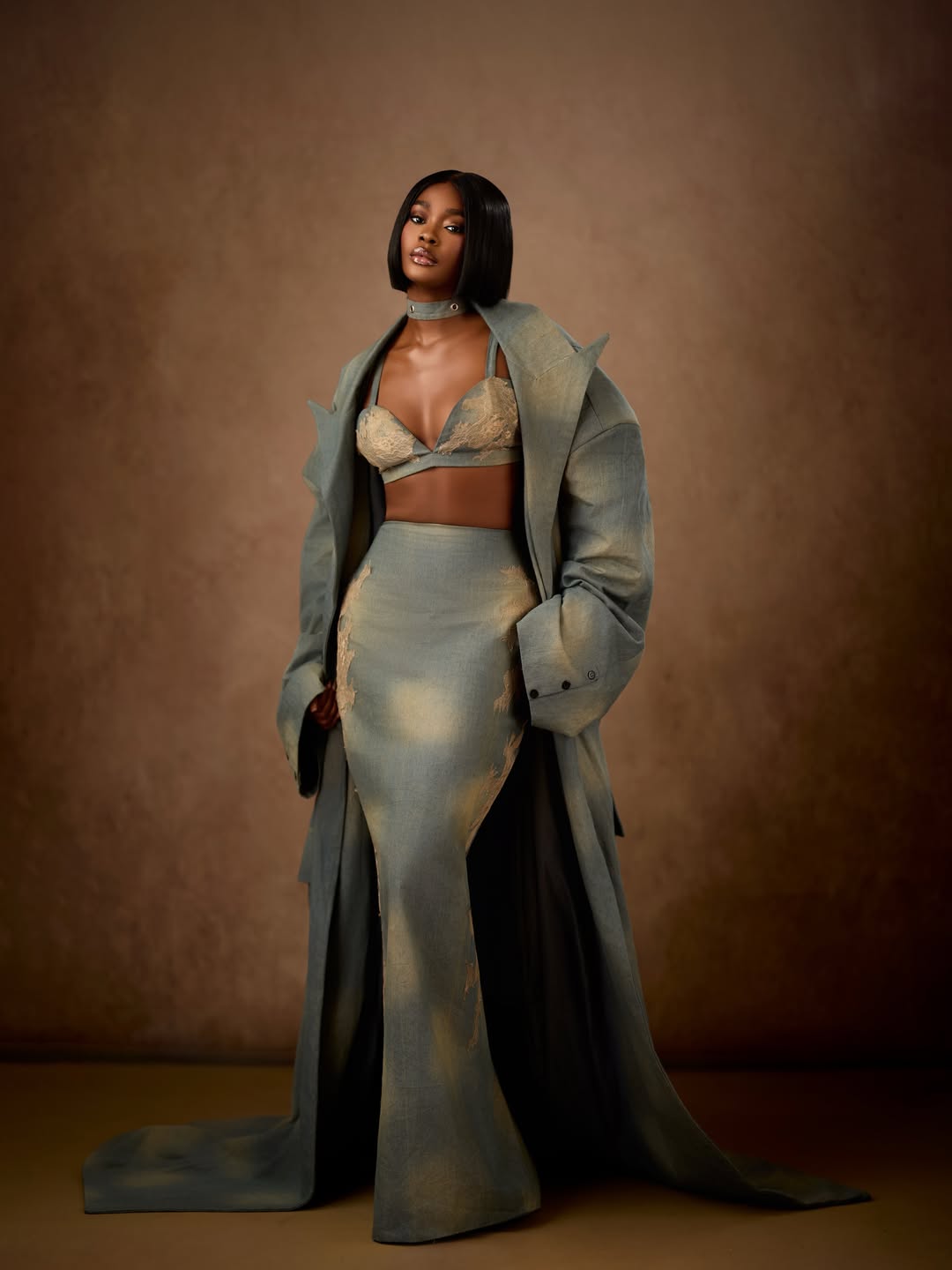 Dede Ashiogwu in an avant-garde custom denim bralette, maxi skirt, and oversized trench coat for the BBNaija Season 10 reunion.