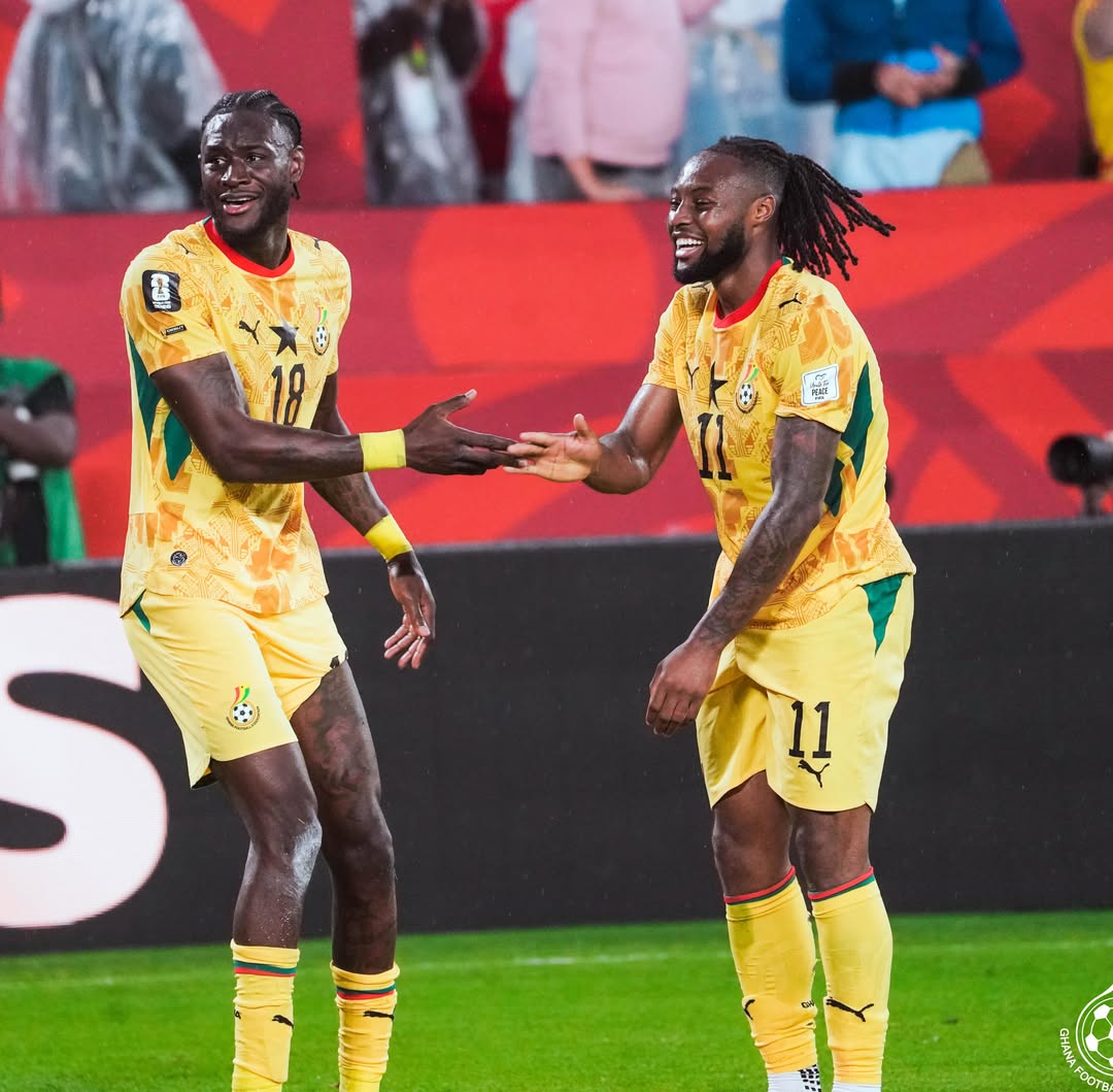 Ghana's Jerome Opoku on the left and Antoine Semenyo on the right sharing a handshake and smiling during their World Cup group stage opener