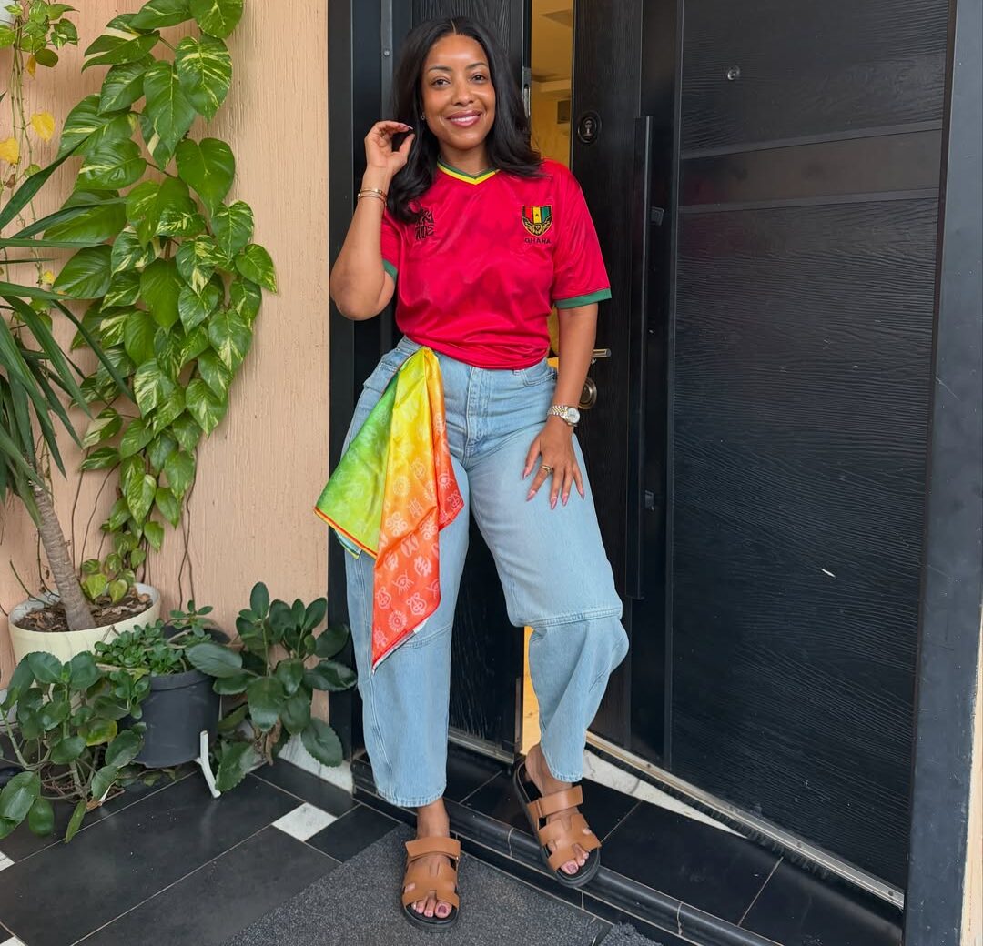 Actress Joselyn Dumas styles a retro red Ghana national team football jersey with wide-leg denim jeans for the 2026 FIFA World Cup fixture against Panama.
