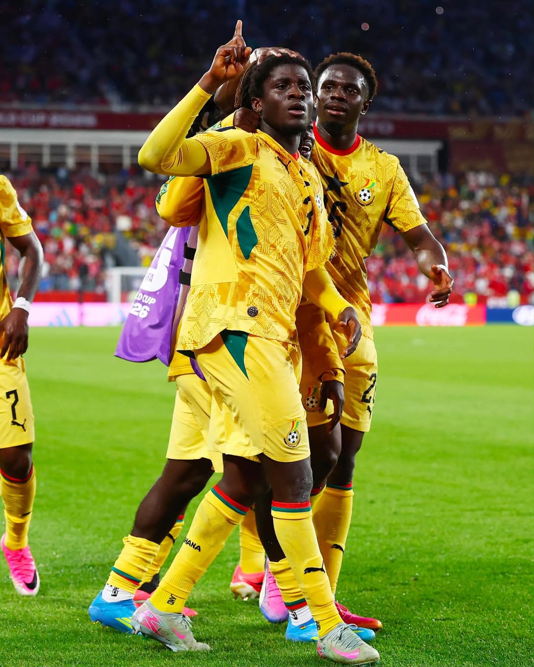Ghanaian midfielder Caleb Yirenkyi pointing upward while celebrating his stoppage-time winning goal with teammates during the World Cup opener against Panama.