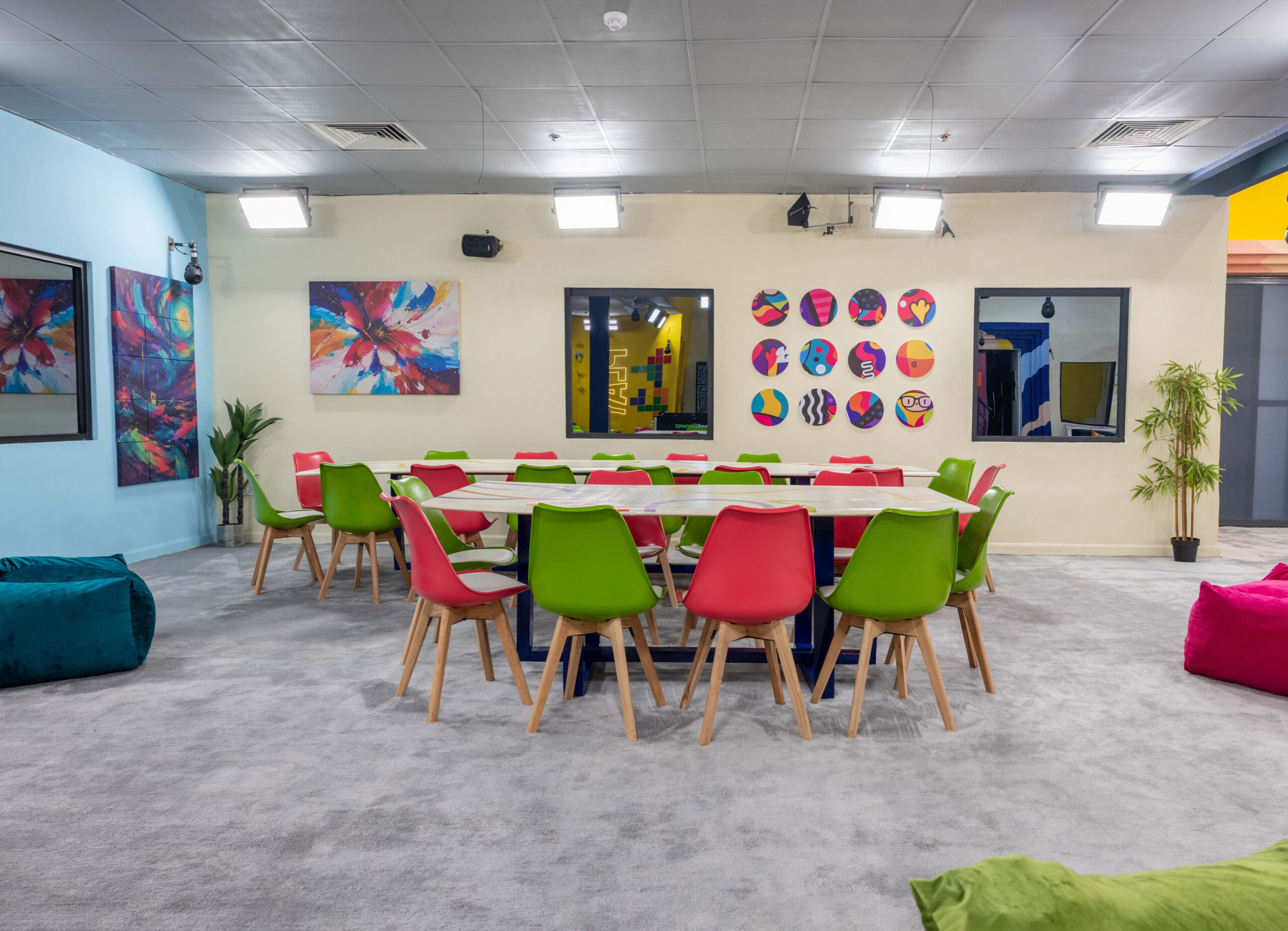 Spacious dining area in the Big Brother Naija Season 11 house with green and red chairs around a long dining table