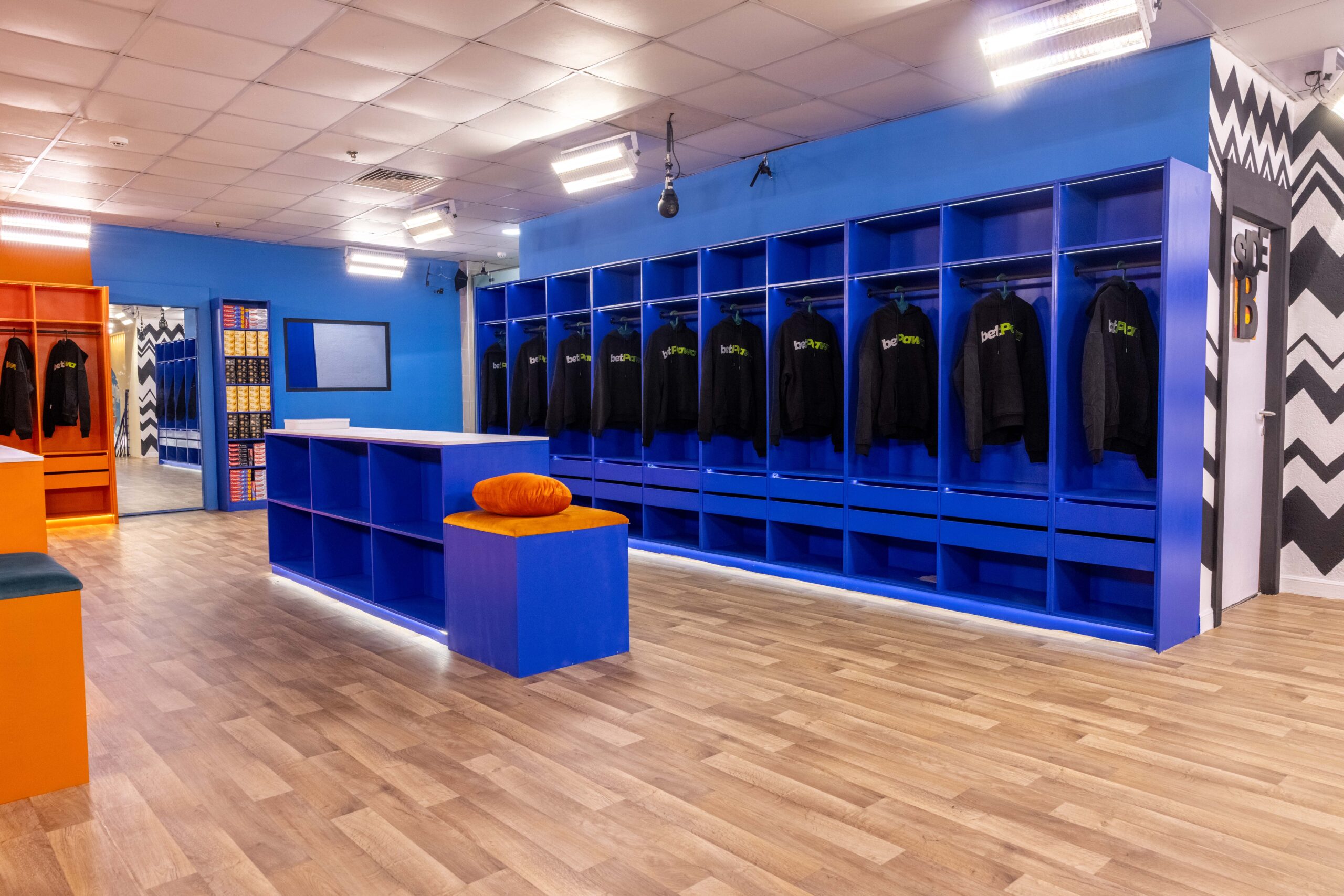 Blue dressing room and closet lockers in the Big Brother Naija Season 11 house stocked with black hoodies