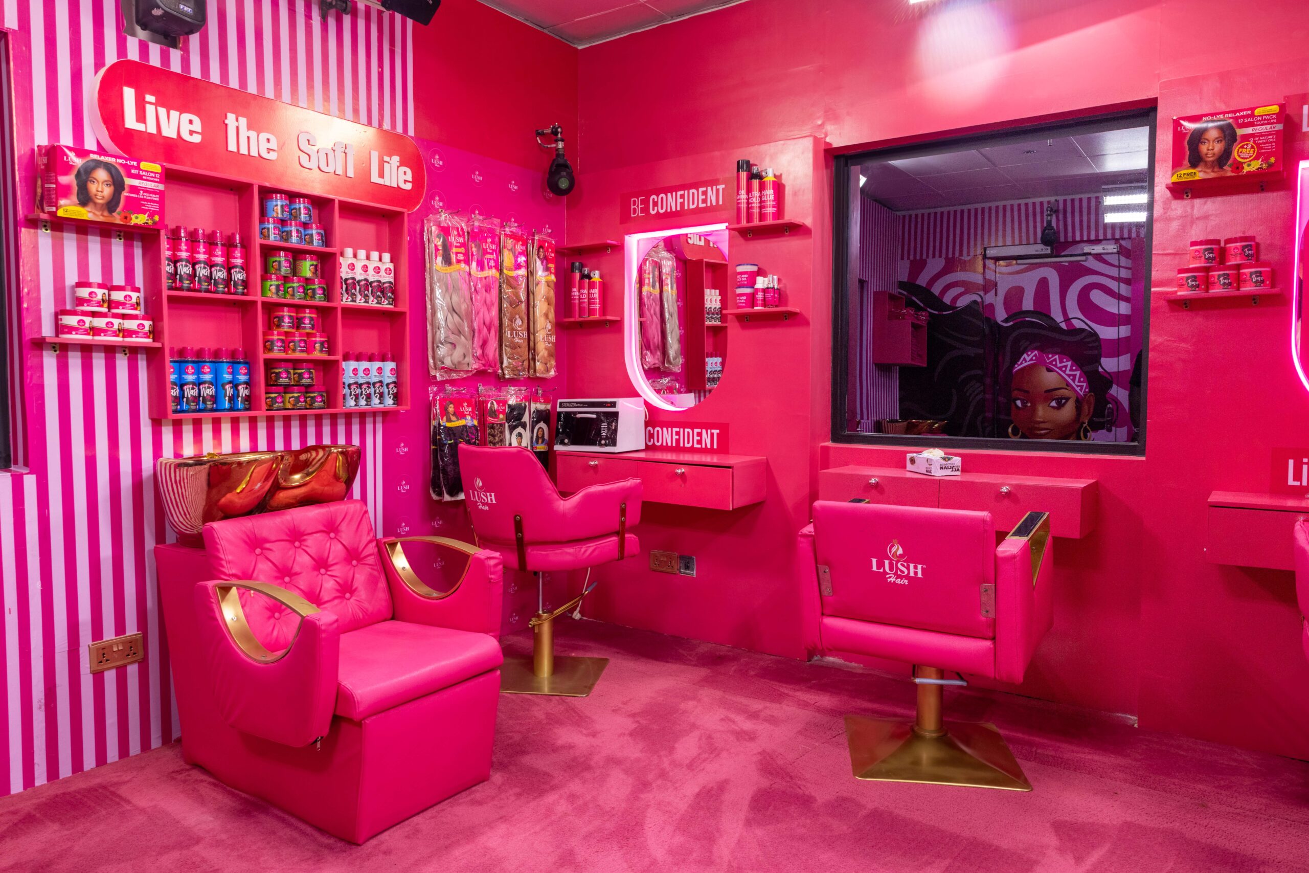 Vibrant pink Lush Hair beauty salon in the Big Brother Naija Season 11 house featuring styling chairs, hair washing basins, mirrors, and hair products