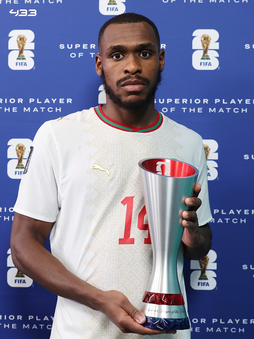 Morocco's Issa Diop wearing a number 14 white kit holding the official FIFA Player of the Match trophy.