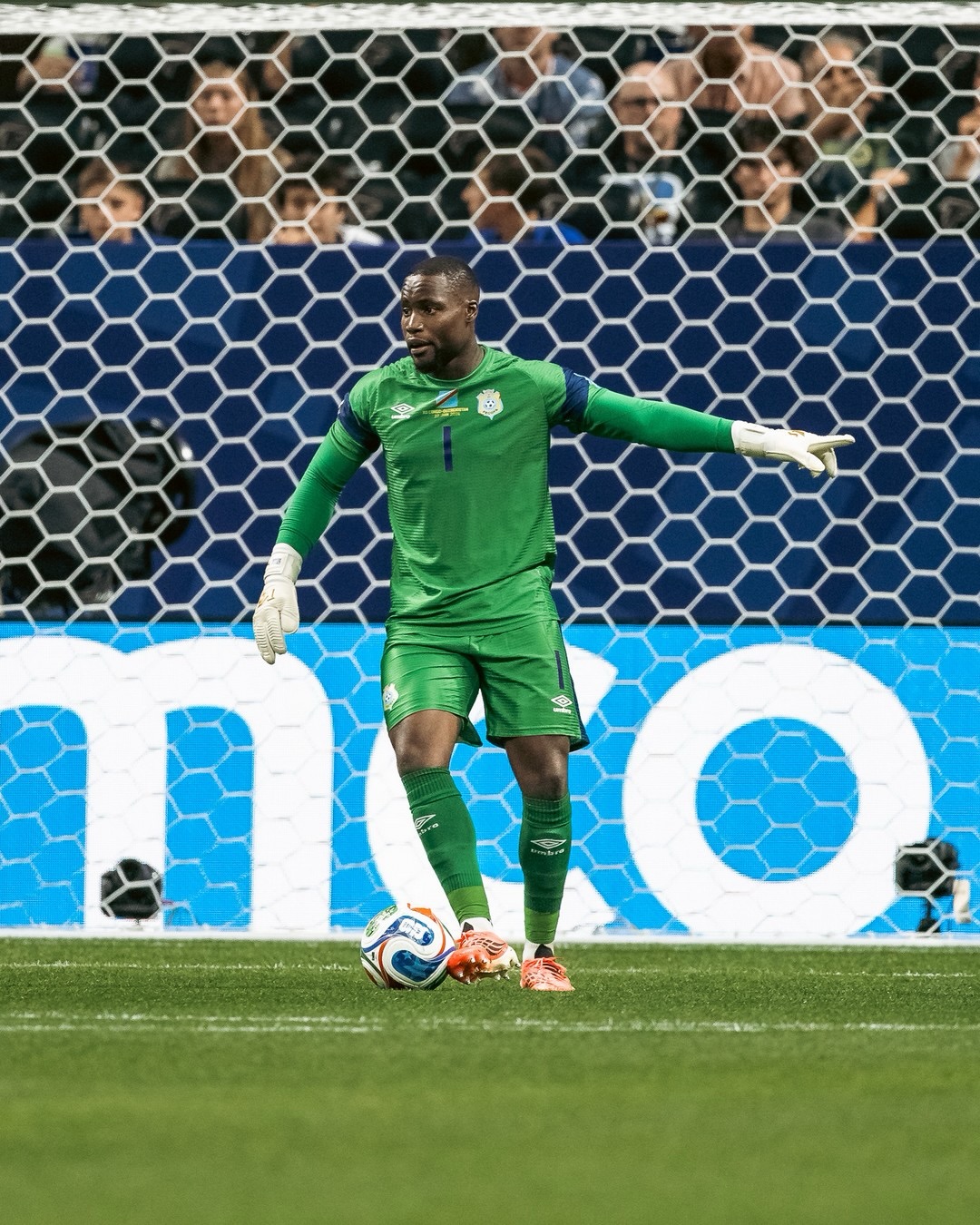 DR Congo goalkeeper Lionnel Mpasi in a green jersey pointing to direct his defense during the World Cup warm-up match against Uzbekistan.