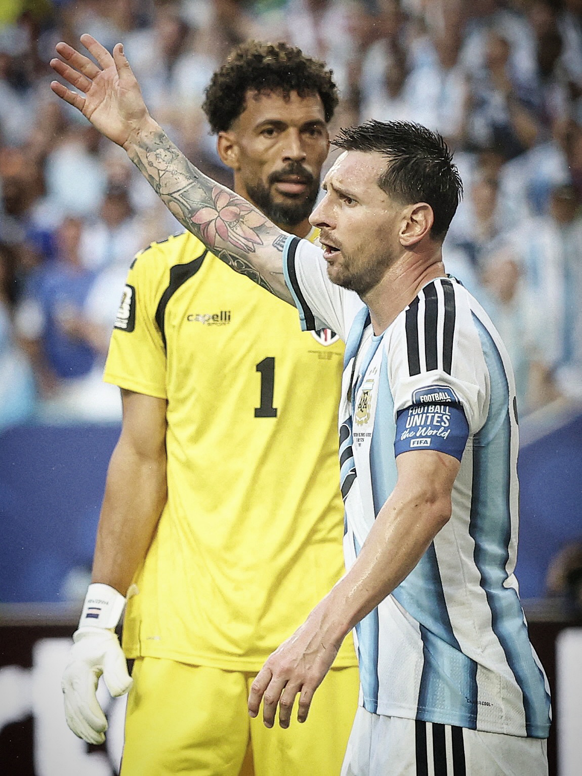 Argentina forward Lionel Messi gesturing on the pitch with Cabo Verde goalkeeper Vozinha standing in the background.