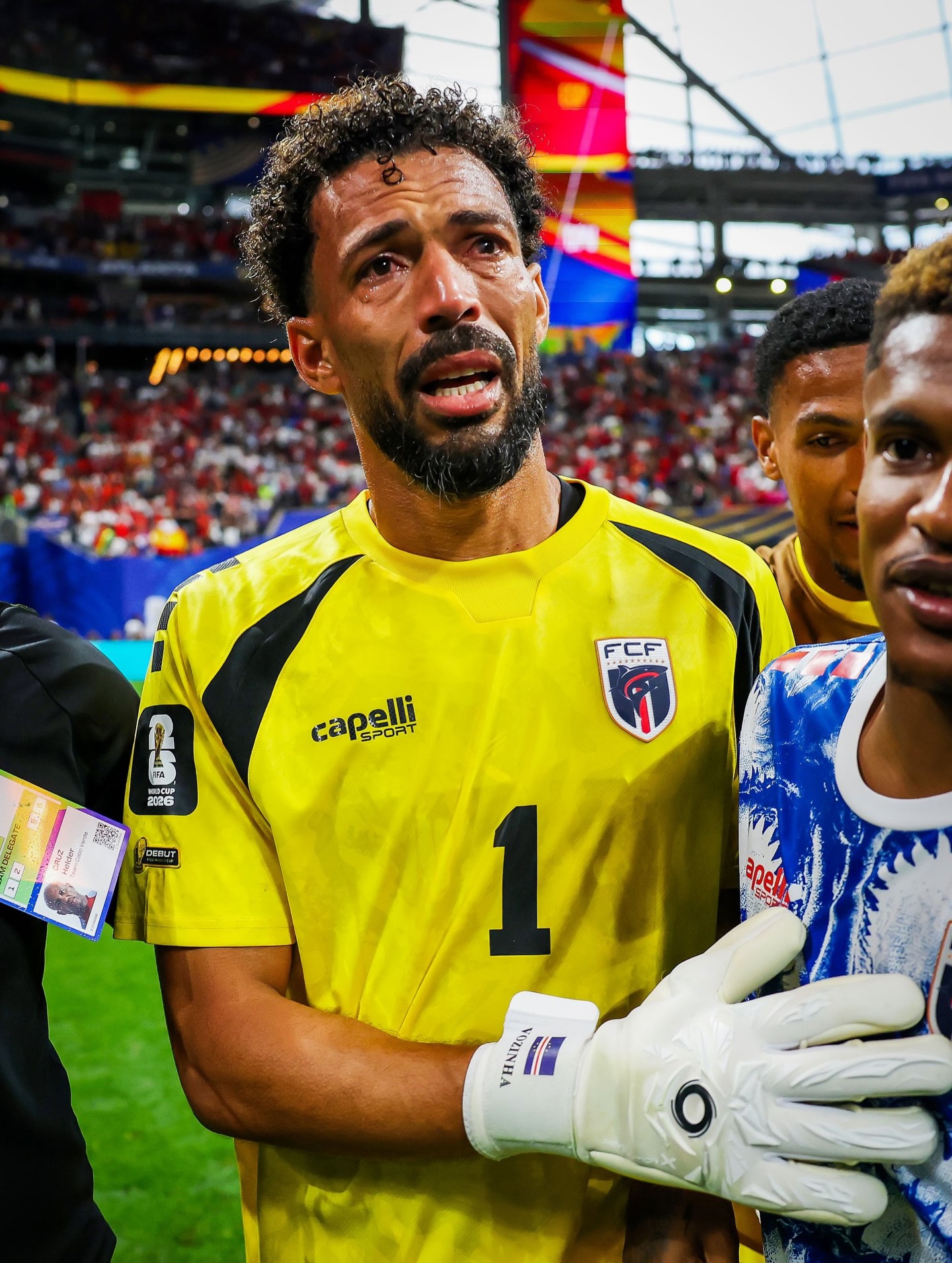 Cabo Verde goalkeeper Vozinha crying on the pitch in his yellow number 1 jersey and white goalkeeper gloves.