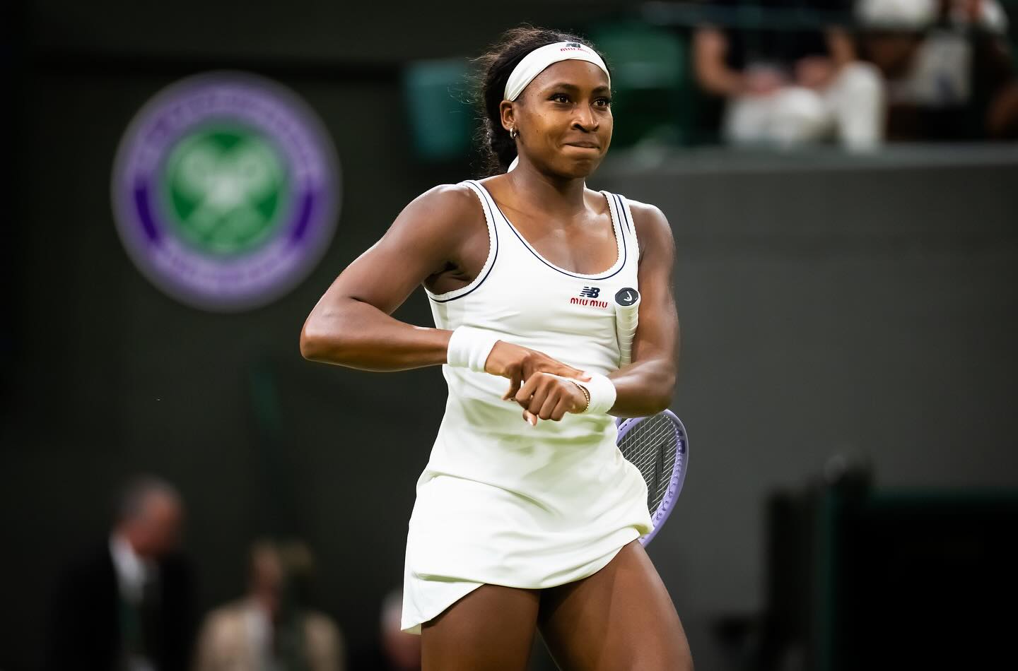 Coco Gauff smiling and hitting her signature "clock it" victory gesture on Centre Court after winning her Wimbledon quarter-final.