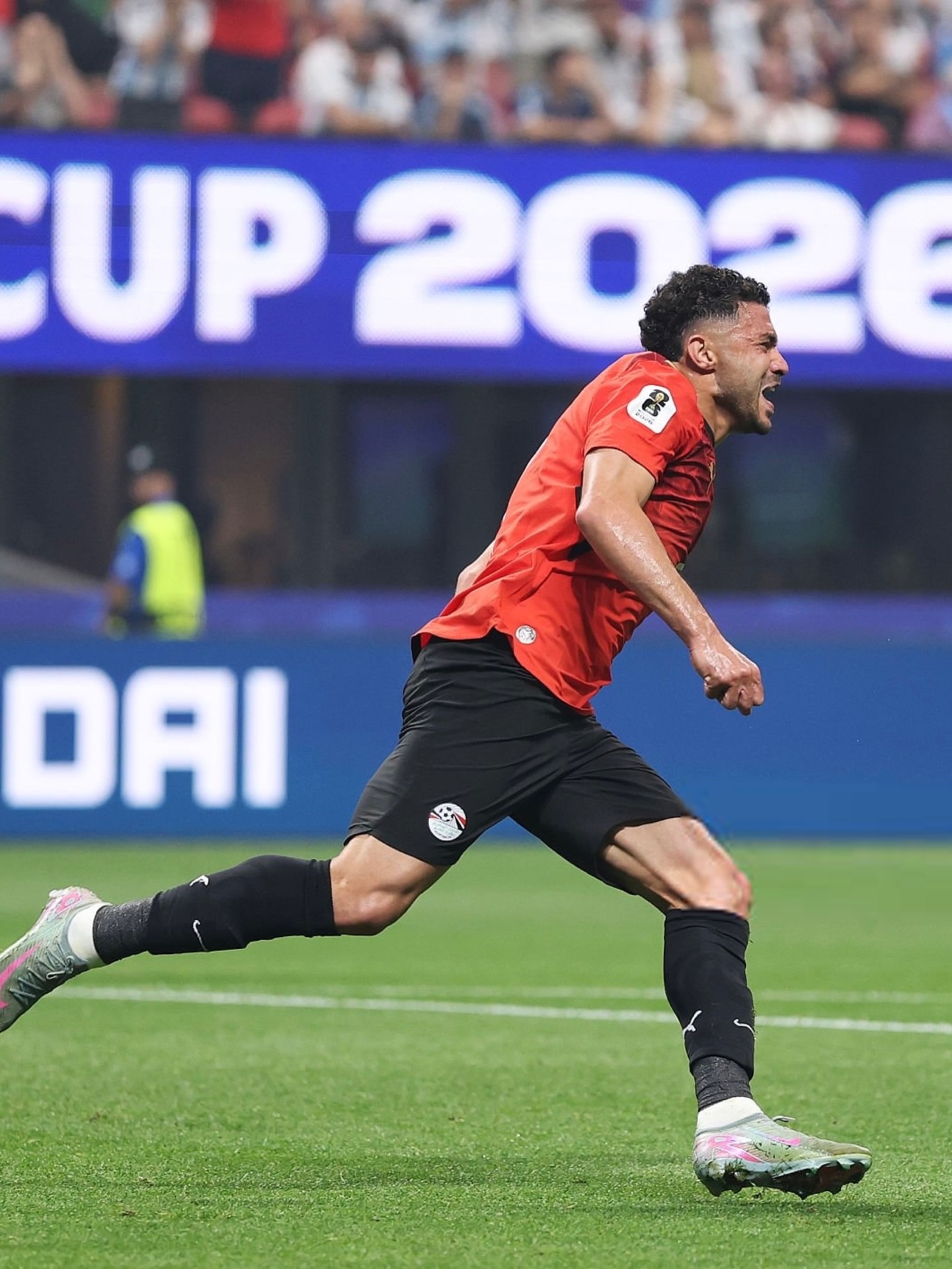 Egyptian forward Mostafa Ziko running on the pitch to celebrate a goal during the 2026 World Cup finals.