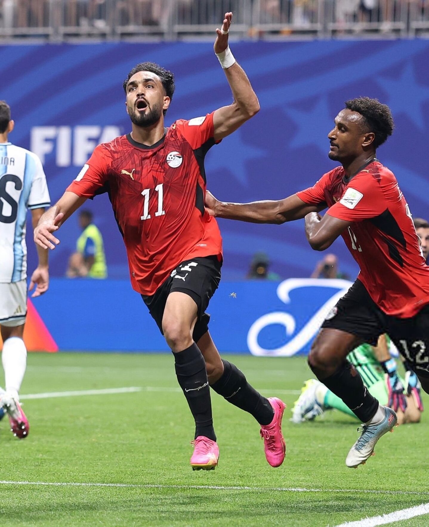 Yasser Ibrahim shouting in celebration after scoring Egypt's opening goal against Argentina with teammate Haissem Hassan.