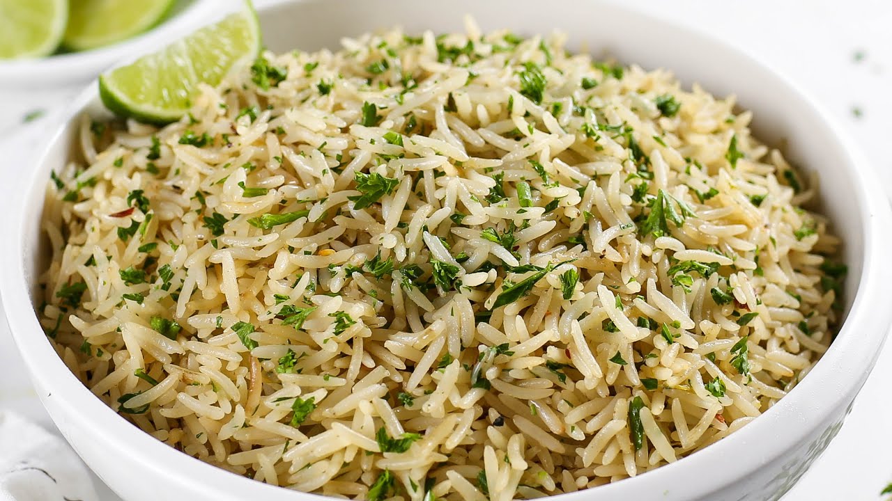 Kikifoodies garlic herb rice topped with fresh chopped herbs and a lime wedge.